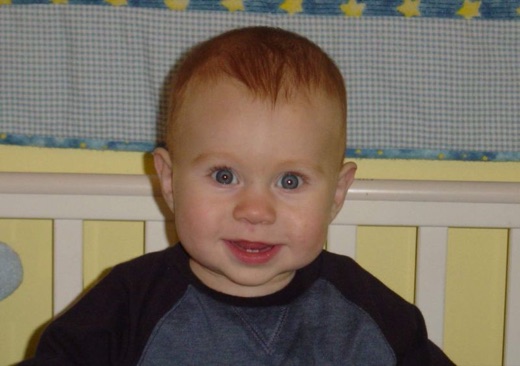 Alex sits up in his crib when he's had enough sleep. Here he is giving us a cheeky grin.